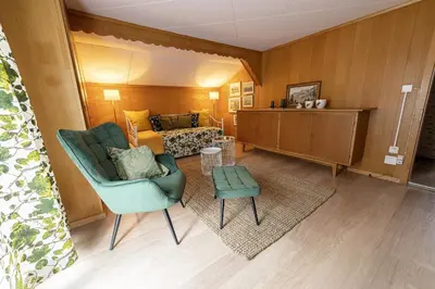 a living room with a couch and a chair at Capanna in Wildhaus