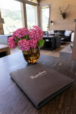 a vase filled with pink flowers on a table at Primula in Wildhaus