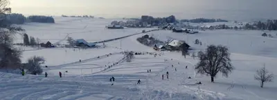 a group of people skiing down a snow covered slope at Appartement Unterstädeli Engelburg SG in Wittenbach