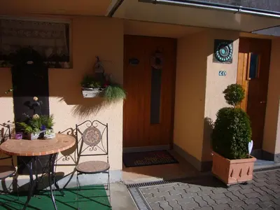 a house with a table and chairs in front of a door at Reni's Oase am Bodensee in Kesswil