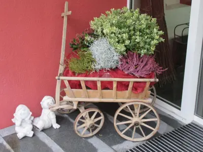 a wooden cart filled with plants on a porch at Hotel Rössli in Zuzwil