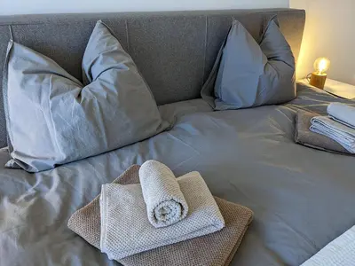 a bed with two towels and pillows on it at Alte Brauerei Buchs in Buchs