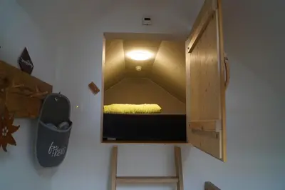 a small room with a bed in a cabinet at Gästehaus Aemisegg in Sankt Peterzell