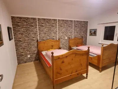 two beds in a room with a brick wall at 24-7 Rooms in Sennwald