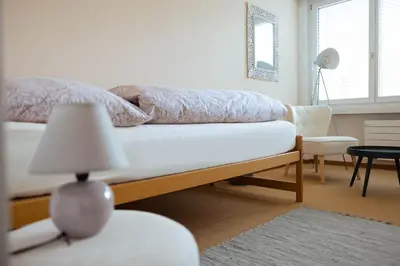 a bedroom with a bed and a table with a lamp at Luxury apartment with terrace and garden free parking smart TV etc in St. Gallen