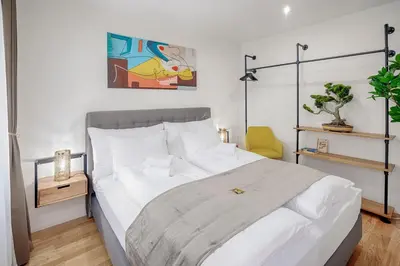 a bedroom with a large bed with white sheets at VISIMO Apartments St Georgen-Strasse St Gallen - Design City Nature in St. Gallen