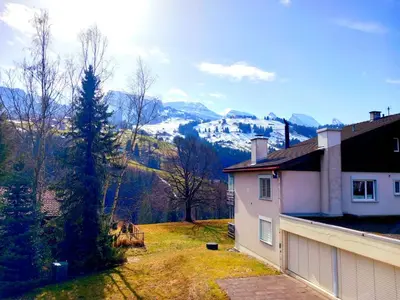 a house with a view of a snow covered mountain at Beautiful holiday apartment in Wildhaus Toggenburg in Wildhaus