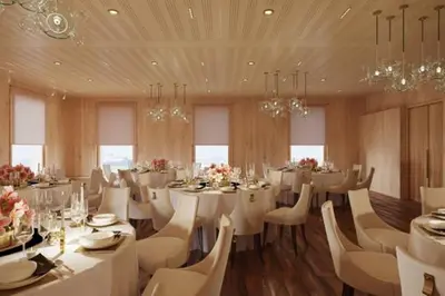 a dining room with white tables and chairs and chandeliers at Appenzeller Huus Löwen in Gonten