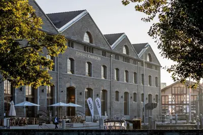 a large brick building with umbrellas in front of it at Business Appartement 1 am Bodensee in Romanshorn