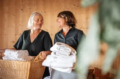 two women standing with a basket of towels at Fischerhäuser Romanshorn in Romanshorn