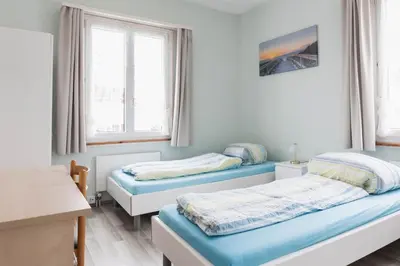 two beds in a room with two windows at Landgasthof Adler in 9304 Bernhardzell in Häggenschwil
