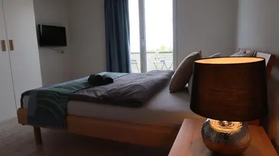 a bedroom with a bed and a lamp on a table at MBar in Altnau