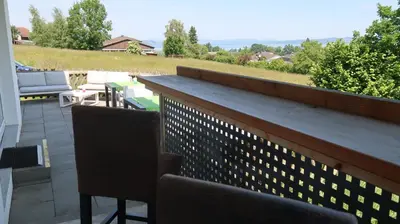 a balcony with two chairs and a counter top at MBar in Altnau