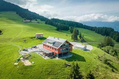 a house on top of a green field at Hotel Restaurant Berghaus Malbun Buchserberg in Buchs