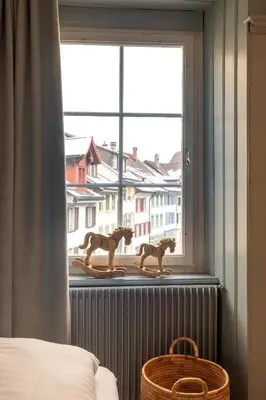 a bedroom with a window with two toy horses on a window sill at JACOB 1808. fine historic town apartments in Bischofszell