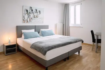 a bedroom with a bed with a table and a window at Hotel & Restaurant Nollen in Hosenruck