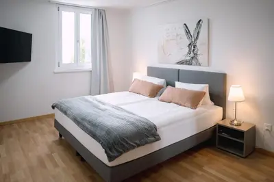a bedroom with a bed with white sheets and a window at Hotel & Restaurant Nollen in Hosenruck