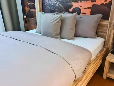 a bed with white sheets and pillows at Ferienhausträume Oase Bodensee in Kreuzlingen