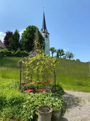 a garden with a church in the background with a tower at Ferienwohnung Florida in Stein